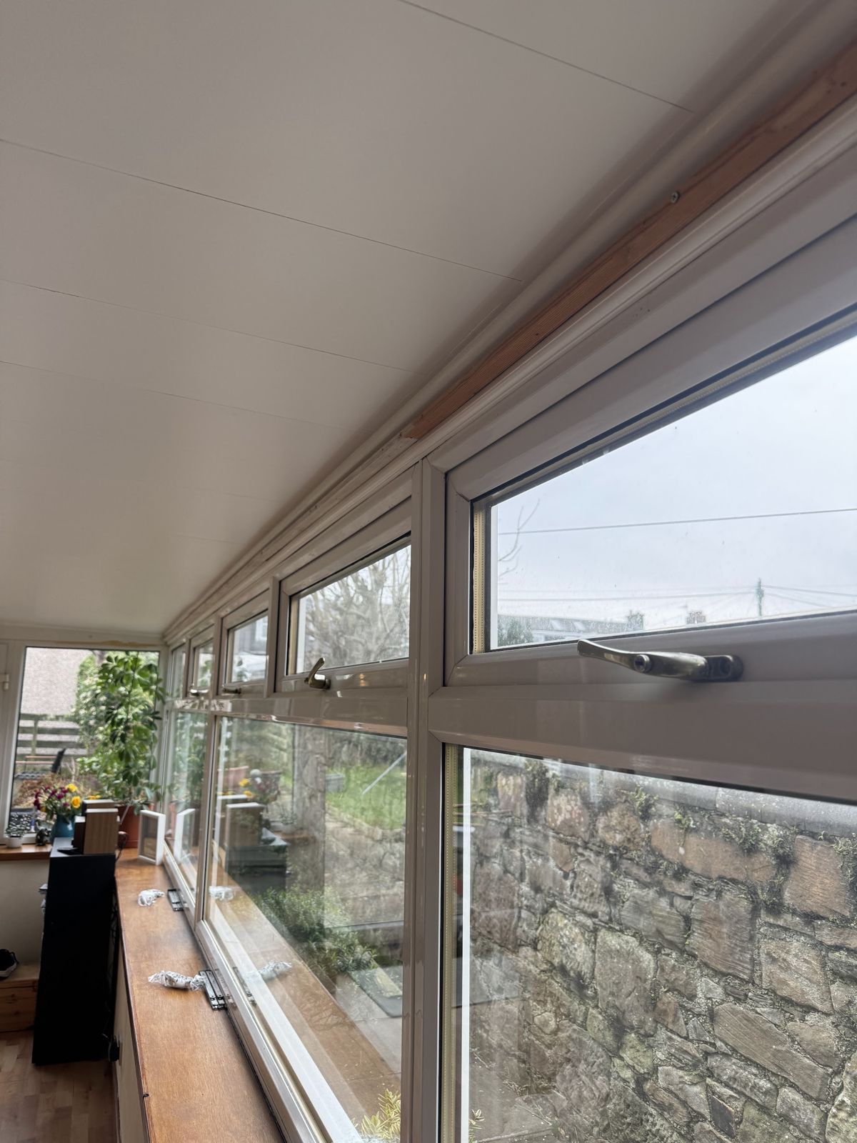 A long run of white uPVC conservatory windows with new handles