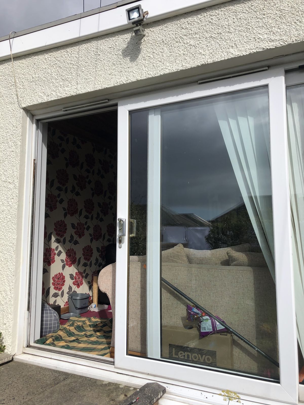 A white uPVC patio door slid open onto a garden path