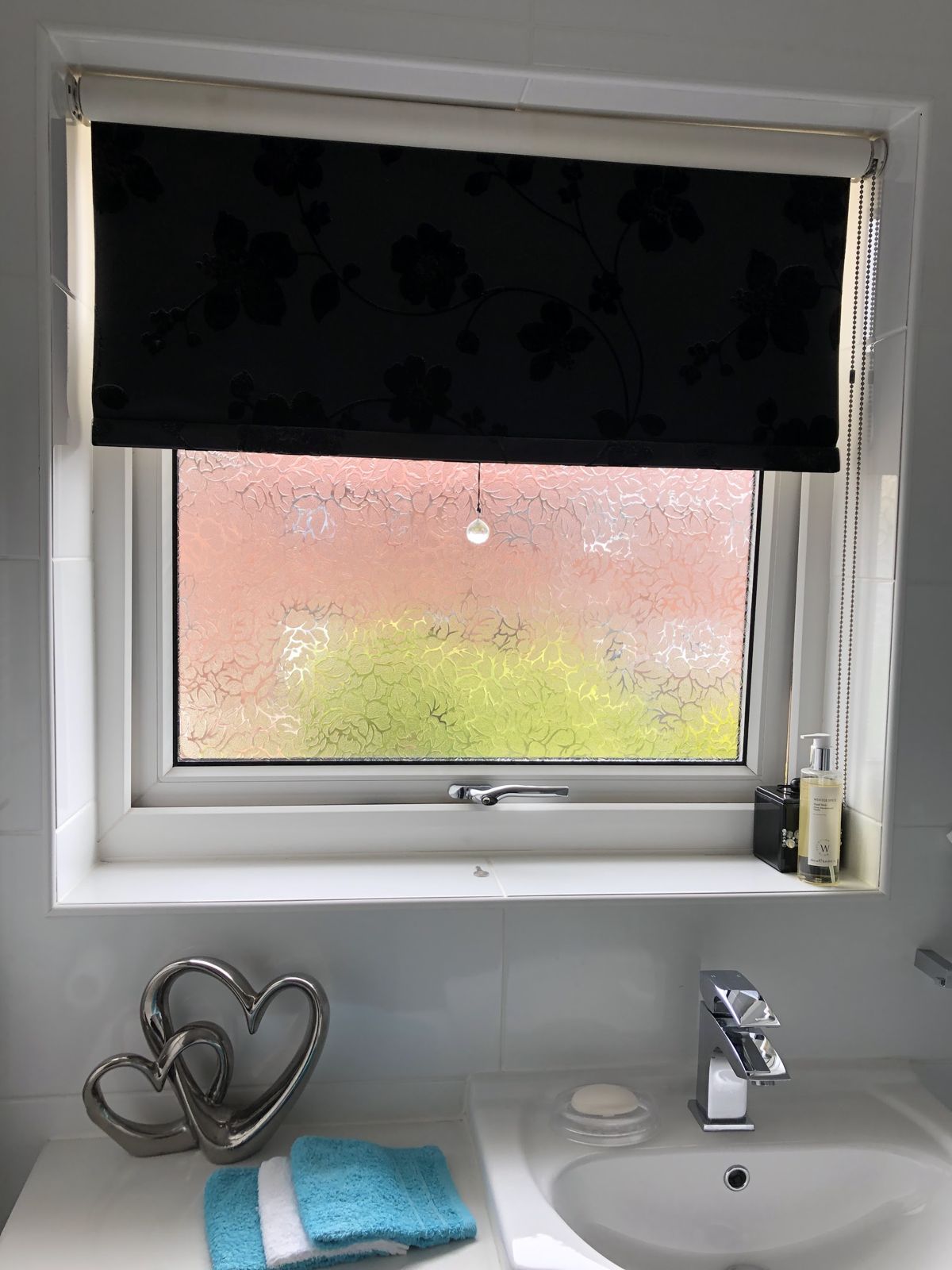 A white bathroom window with obscure glass above a sink