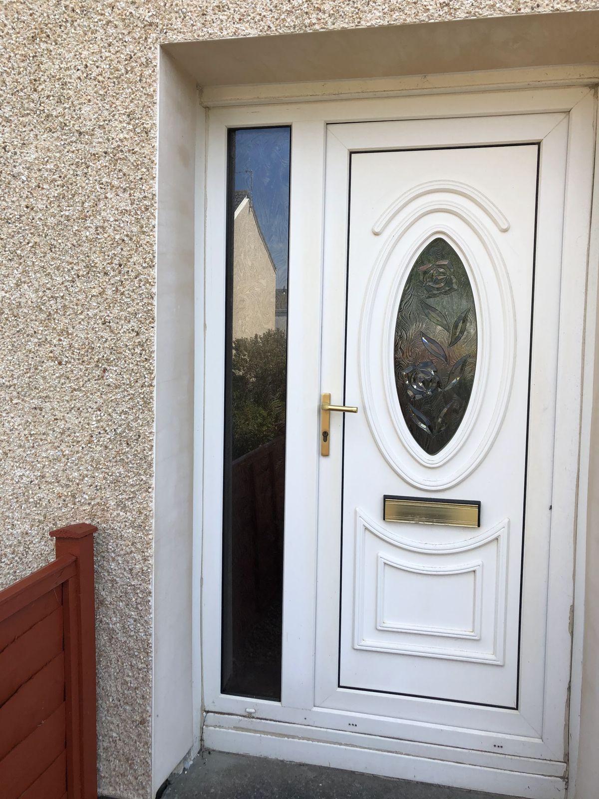 A white uPVC front door with an oval glass panel and side light